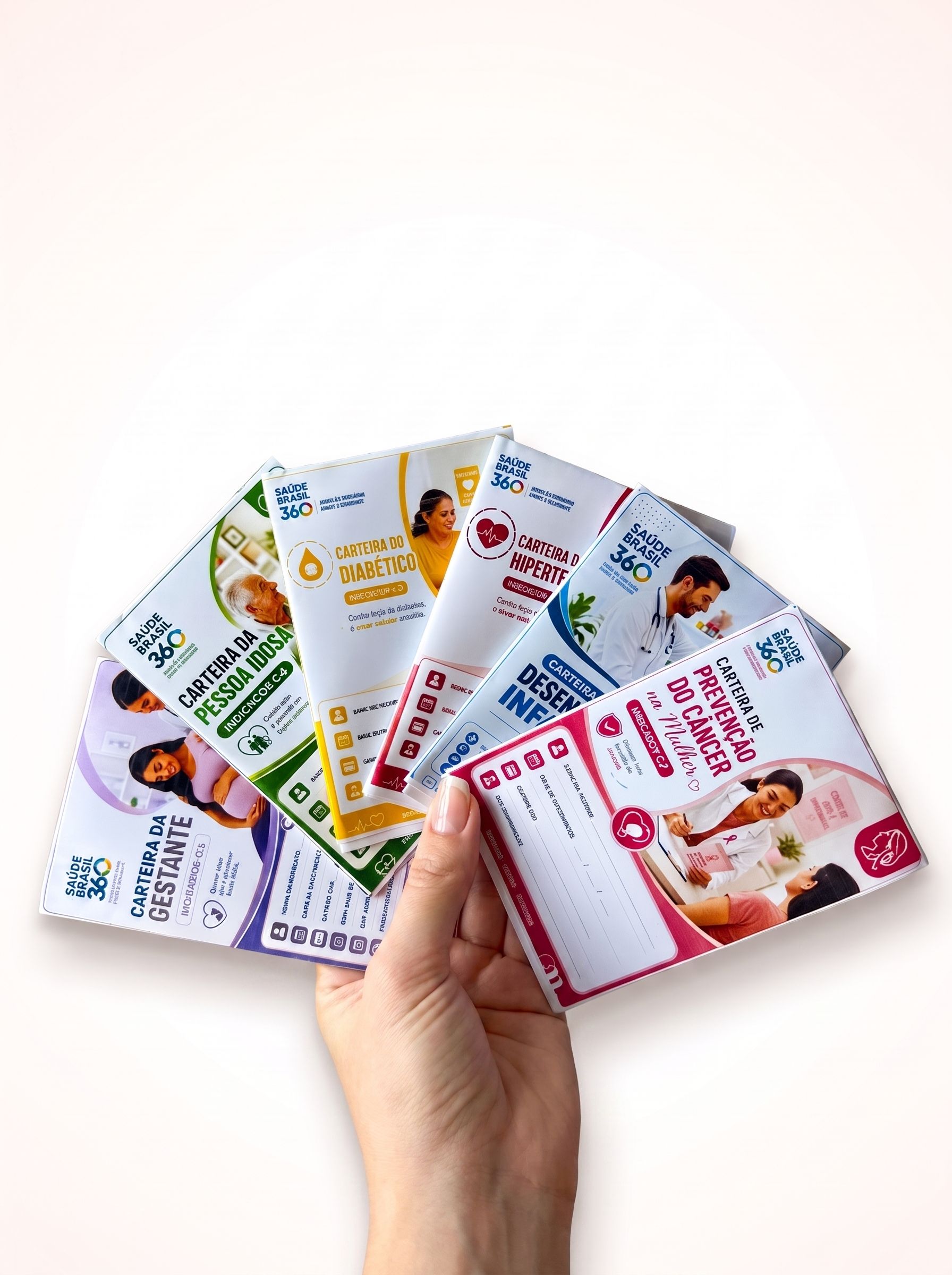 Mão segurando as 6 carteirinhas do Kit Saúde Brasil 360 em leque